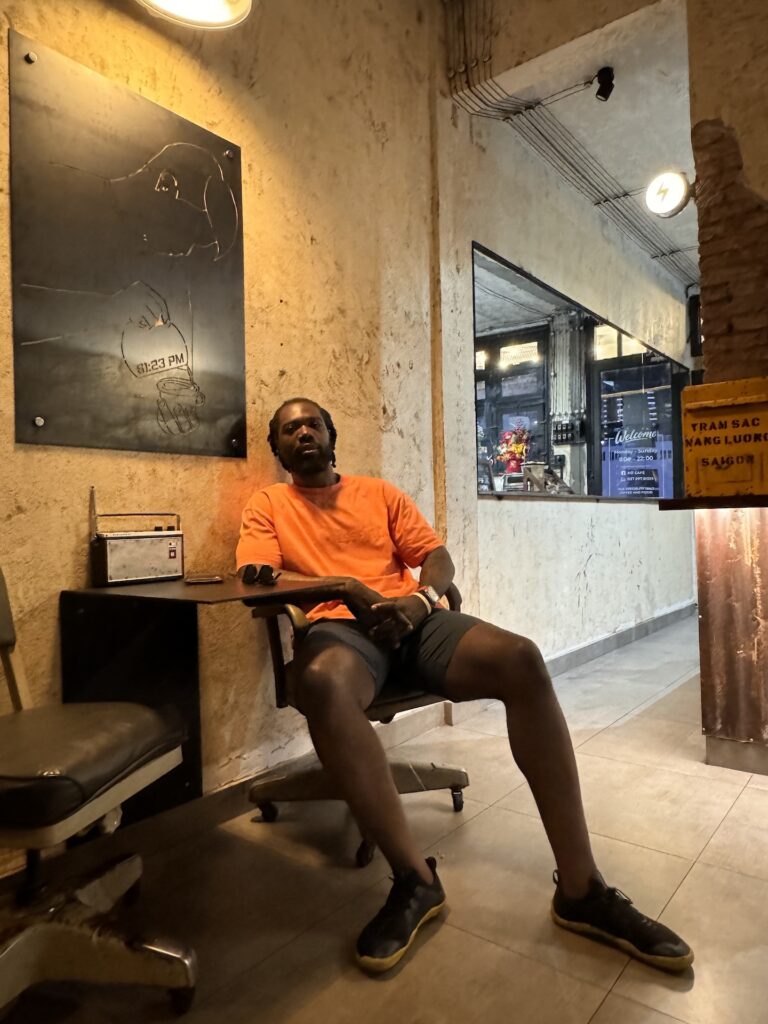 Man sitting in a vintage café in Ho Chi Minh City, reflecting over coffee and exhaustion.