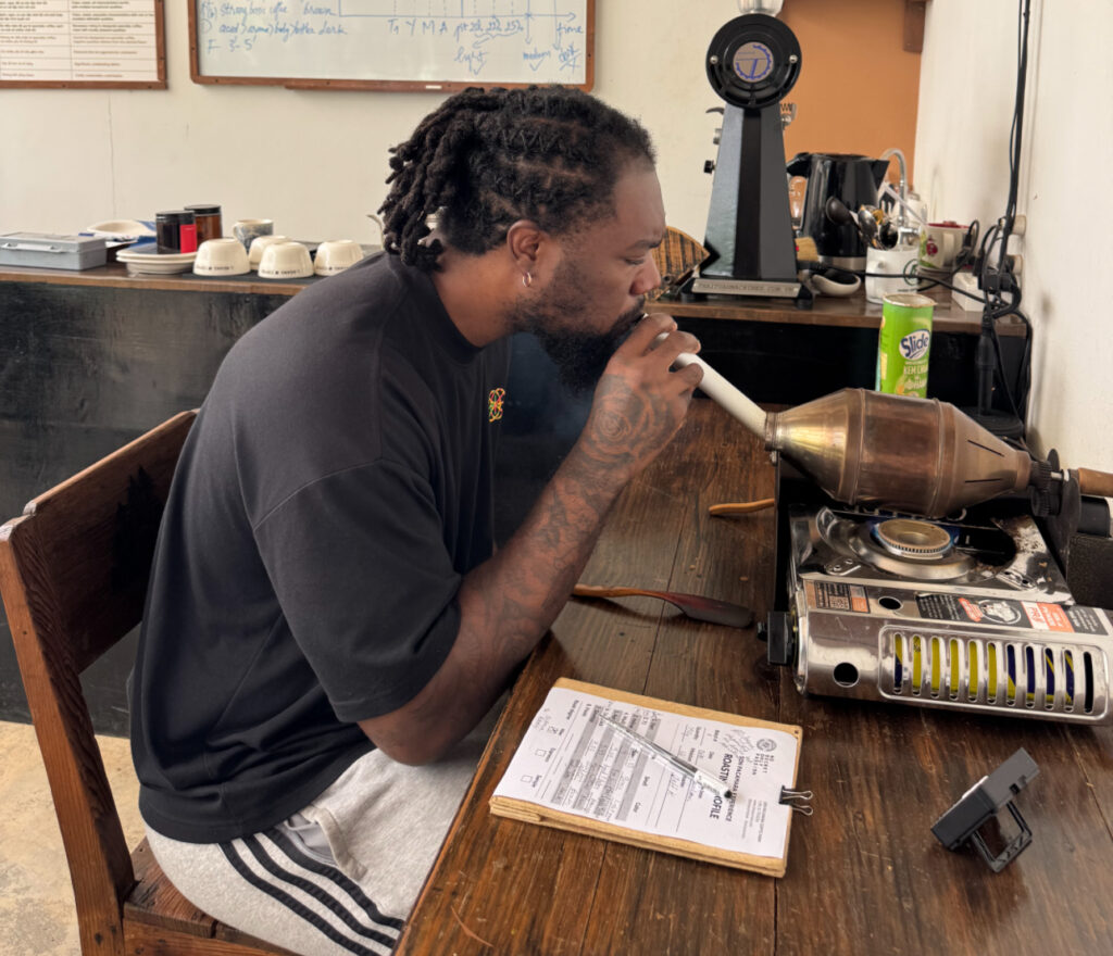 Man roasting coffee at a specialty coffee farm in the mountains of Dalat, Vietnam.